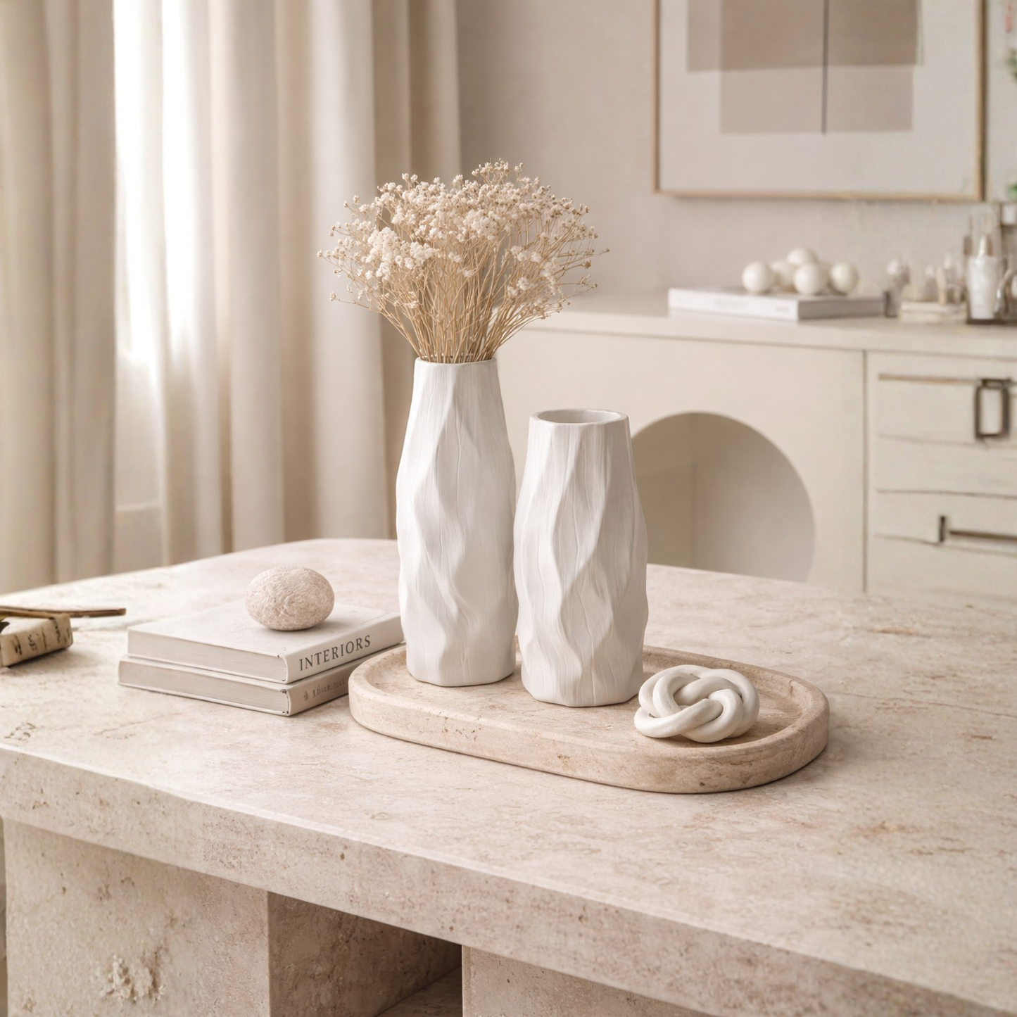Pleated ceramic vase styled with delicate branches in a warm neutral interior with natural textures and minimalist decor.