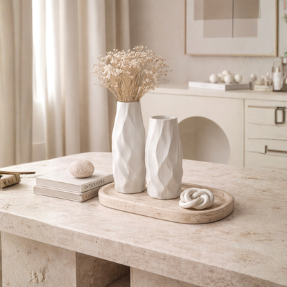 Pleated ceramic vase styled with delicate branches in a warm neutral interior with natural textures and minimalist decor.