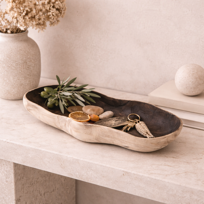 Sculptural natural wood tray styled in a warm neutral interior with organic textures and minimalist decor.